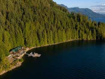 Resort am Wasser mit Nadelbäumen in Kanada
